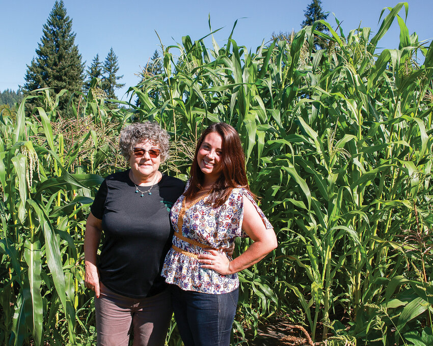 The owners of Mindful Creations LLC, Judy Canter, left, and Diana Peterson stand amid corn in their produce field on Sept. 6