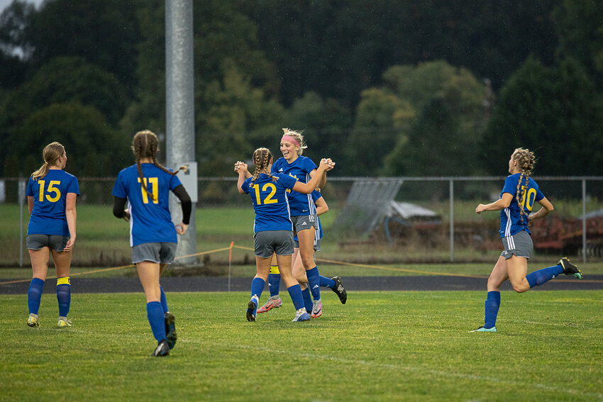 Lydia Tobin is all smiles while celebrating with Lilly Wellander (12) and her teammates after scoring the first of her three goals on Sept. 25.