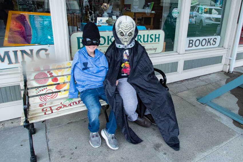 CJ Smith and Cayden Olson sit on a bench in downtown Chehalis with their alien disguises on Saturday, Sept. 23, 2023, during the third annual Chehalis Flying Saucer Party.