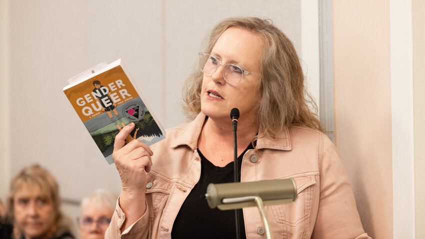 Elizabeth Rohr holds up the book &ldquo;Gender Queer&rdquo; while talking in favor of a book rating system during a public meeting with Lewis County Commissioners on Tuesday, Oct. 10.
