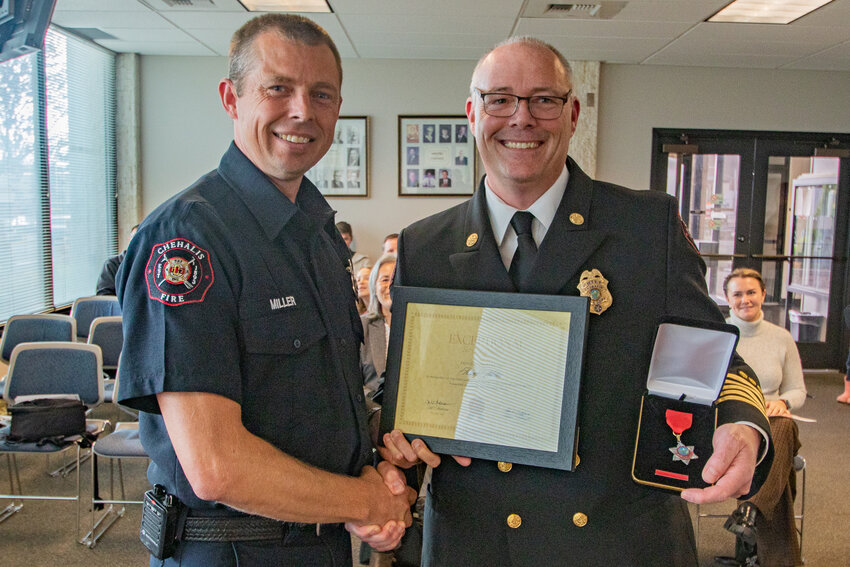 Firefighter Adam Miller, left, poses with Chehalis Fire Chief Adam Fulbright after Fulbright awarded him with an Exceptional Service medal during Monday's Chehalis City Council meeting on Oct. 9.