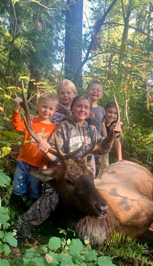 This picture was submitted by proud husband Colton Stevens. It shows his wife, Kaydee Stevens, who is in front holding horns. Kaydee Stevens double lung shot this 5x5 bull elk from 60 yards with her CVA optima muzzleloader shooting 270 grain powerbelt platinum. Colton and Kaydee had their kids out. Pictured behind their mom, from left to right, are Hunter, Kinzlee, Colton Jr., and Kodah. They learned how to clean and process their game. Memories were made. This family&rsquo;s&nbsp; year&rsquo;s worth of meat was taken in the beautiful Ryderwood Game Management Unit 530.