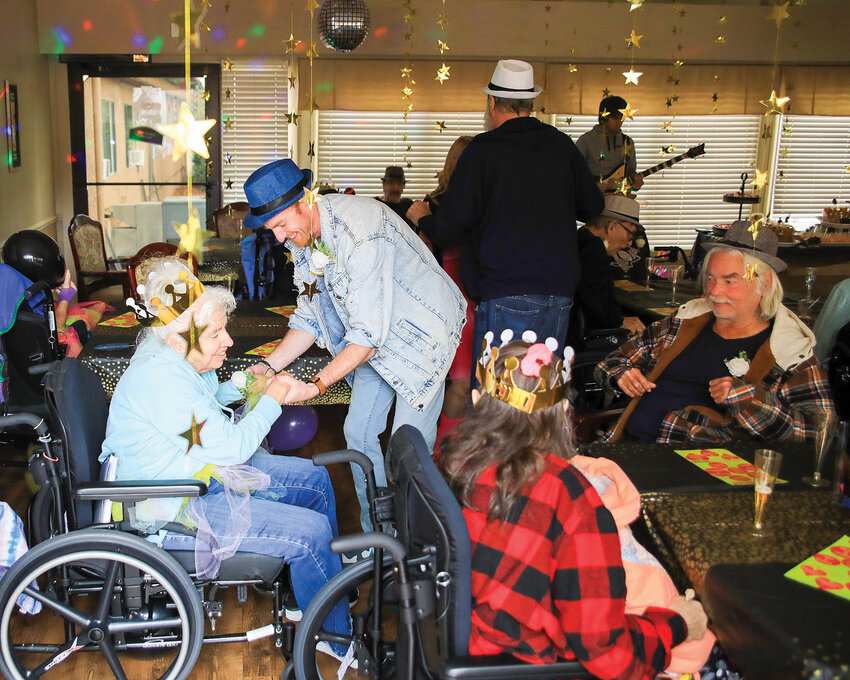 Josh Clark, CEO at Brookfield Health and Rehabilitation of Cascadia, dances with a resident during Brookfield&rsquo;s 1980s-themed prom event on Oct. 4.
