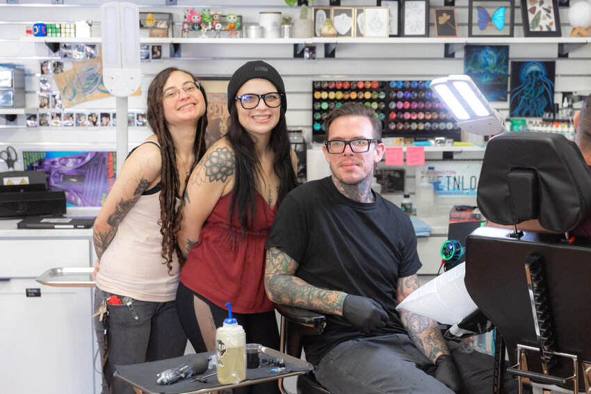 From left, artist Rahne Holloway, owner Candi Beaver and artist Josh Paulino pose for a photo while working at Cosmic Tattoo in downtown Centralia on Thursday, Oct. 12.