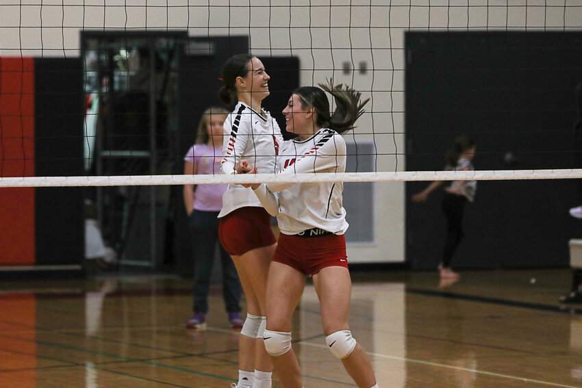 Chesney Schultz and Saydi Mendoza celebrate after the Vikings took the first set in their win on Oct. 19.