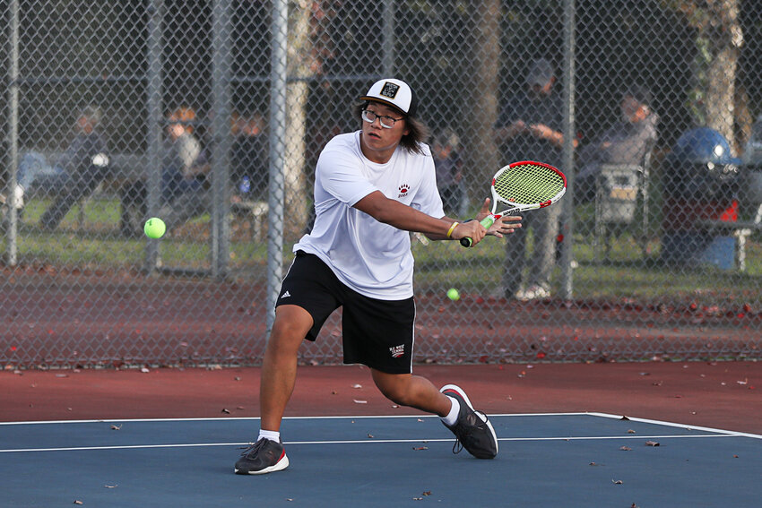 Justin Chung lunges forward to backhand the ball during the second day of the 2A Evergreen tournament on Oct. 19.