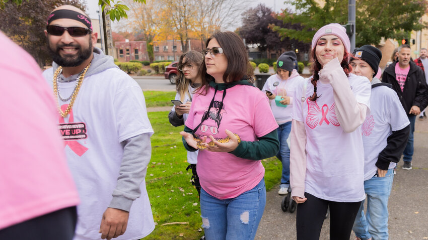 Attendees smile and pose while walking together during a Breast Cancer Awareness March in downtown Centralia Saturday morning.