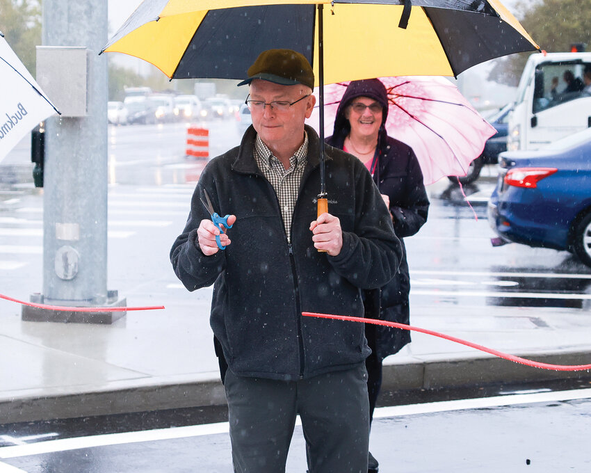 Battle Ground mayor Philip Johnson cuts the ribbon at the new right turn lane from northbound Southwest 10th Avenue onto West Main Street during a rainy celebration on Monday, Oct. 16.