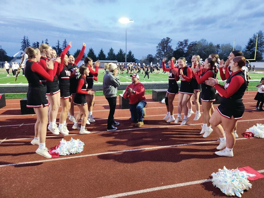 Cheerleaders celebrate after Anthony Romans proposes to his girlfriend Rene Kord before the Yelm homecoming game, Oct. 20.