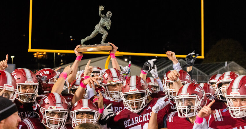 Bearcats raise the Swamp Cup trophy after defeating the Tigers 49-0 under Friday night lights on Oct. 27, in Chehalis.