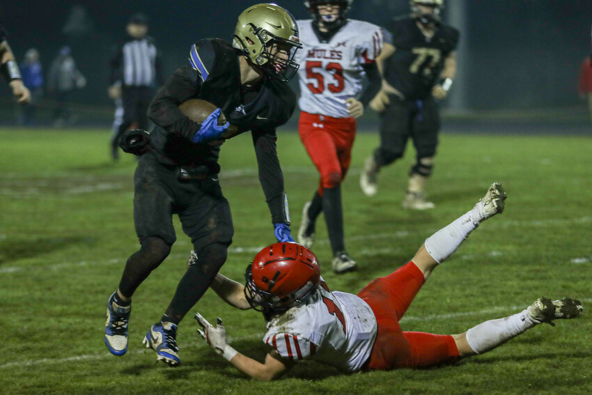 Adna's Luke Mohney stiff-arms a Wahkiakum defender during a 56-6 victory on Oct. 31.