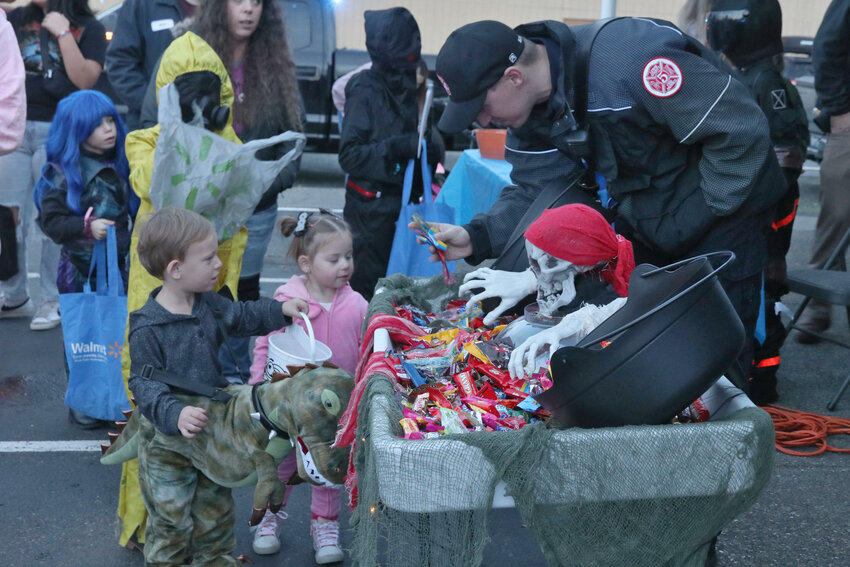 Lewis County Fire District 5 staff hand out candy to trick-or-treaters during a trunk-or-treat event outside the fire station in Napavine on Tuesday, Oct. 31.