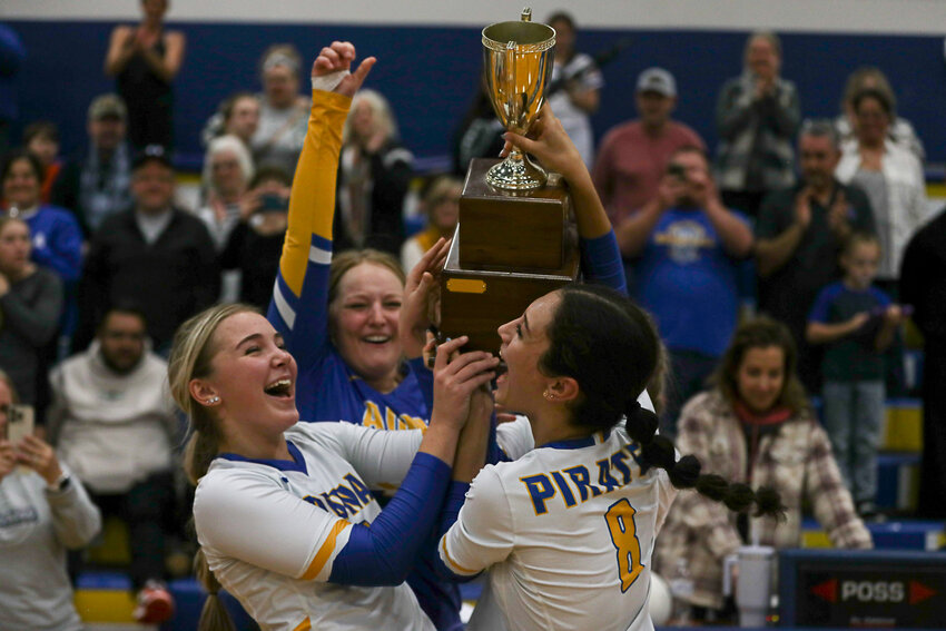From left to right, Danika Hallom, Kendall Humphrey, and Charissa Schierman celebrate with the trophy after winning the 2B District 4 Championship on Nov. 4.