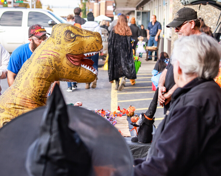 A dinosaur stares down a candy-giver at Battle Ground Festival Association&rsquo;s Trick-or-Treat Trail on Halloween.
