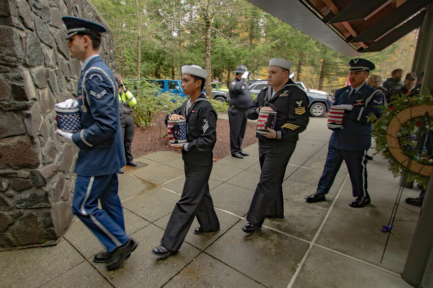 U.S. Air Force airmen and U.S. Navy sailors carry the four veterans whose remains were left unclaimed in Lewis County at Tahoma National Cemetery on Friday, Nov. 10.