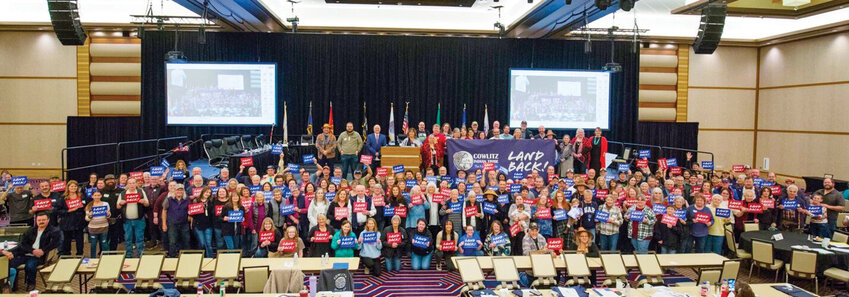 The Cowlitz Indian Tribe General Council poses for a photo with signs reading &ldquo;Land Back&rdquo; in this photo provided by the Tribe.