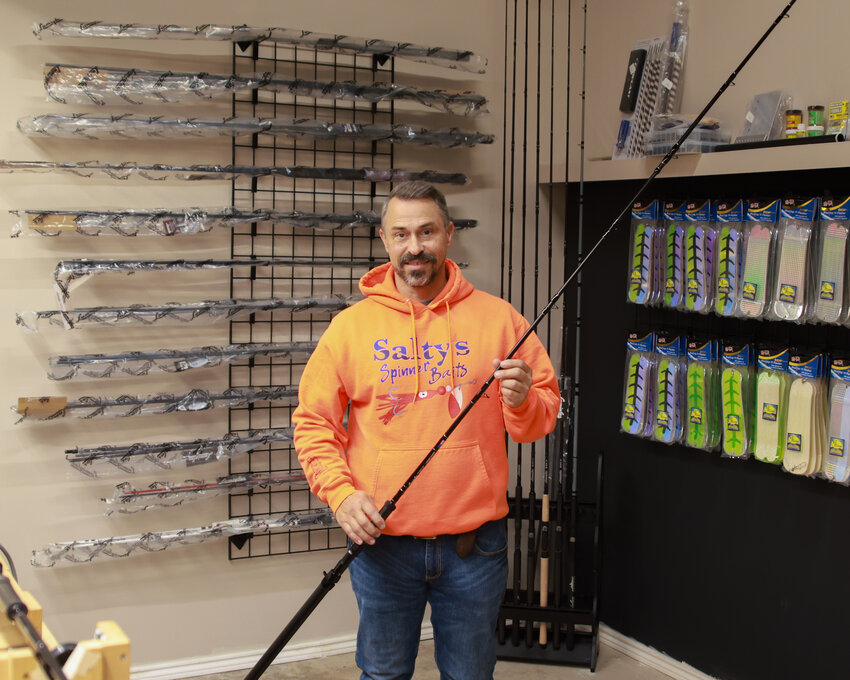 Thomas Hatcher, owner of Salty&rsquo;s Spinners, stands in his Brush Prairie shop with a replica of the Lamiglas Kenai Kwik fishing rod that he built under the guidance of Thomas Hatcher.
