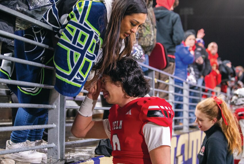 Yelm quarterback Damian Aalona is consoled by a supporter in the stands after the Tornados&rsquo; loss to Bellevue during the 3A state football championship game on Friday, Dec. 1, at Husky Stadium in Seattle.