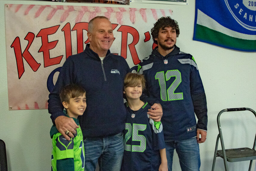 Former Seattle Seahawks kicker Norm Johnson, also known as &quot;Mr. Automatic,&quot; poses with Cohen, in the green, and Bernard Collette along with their father, Tom Collette, at Keiper's Cards on Saturday, Dec. 2. during a card and memorabilia show in downtown Centralia.