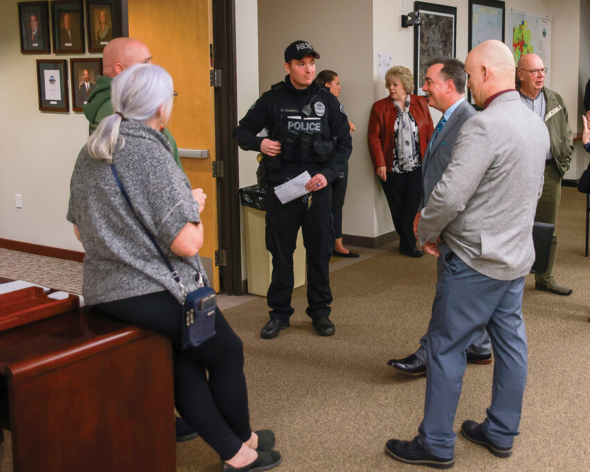 Battle Ground police chief candidates Dennis Flynn and Perry Phipps, right, speak with community members and a Battle Ground police officer during the public meet-and-greet event at City Hall on Thursday, Dec. 7.