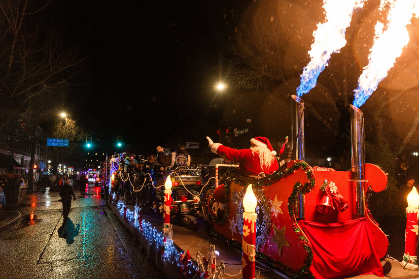 Santa waves a flames rise from the Lewis County &ldquo;A Brotherhood Against Totalitarian Enactments&rdquo; (ABATE) float during the Centralia Lighted Tractor parade on Saturday, Dec. 9. Despite heavy rain throughout the day, thousands of people attended the parade, which moved down Tower Avenue and Pearl Street before returning to the staging area near Centralia College. It was the 14th year for the parade, which is organized and hosted by the Centralia Downtown Association. The grand marshals this year were the students of the Centralia High School FFA program.