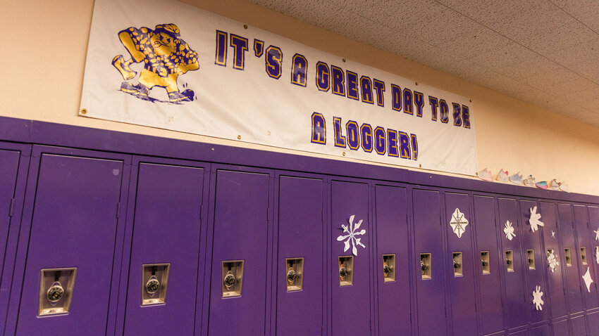 Pictures of shoes decorated by students are seen on a wall above lockers alongside a Onalaska banner inside a hall at the high school on Tuesday, Nov. 28.