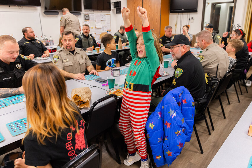 Participants celebrate while playing bingo during Shop with a Cop at the Lewis County Sheriff&rsquo;s Office in Chehalis on Wednesday, Dec. 13.