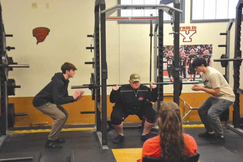 Yelm freshman Alex Gordon, center, attempts his first squat at 135 pounds at the Yelm High School powerlifting meet, Dec. 12.