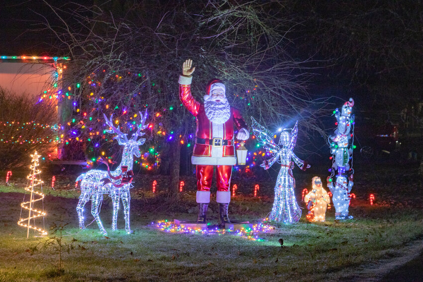 Santa is illuminated and waves to passersby on Thursday, Dec. 14, in a yard along state Route 508.