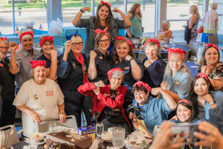 Doris Bier smiles and poses for a photo as attendees dress like Rosie the Riveter during a Power of the Purse event in the TransAlta Commons at Centralia College on Tuesday, Aug. 1, 2023.
