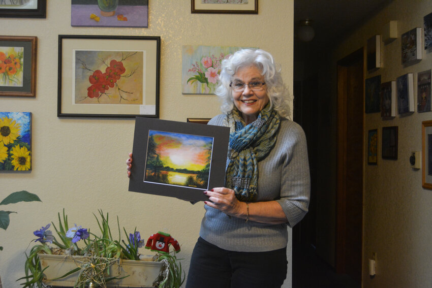 Deborah Ann Baker poses with a print of her piece &quot;Serenity&quot; that was submitted for the Manhattan Arts International's exhibition on Dec. 22.