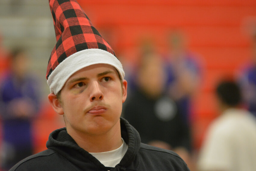 Yelm heavyweight Jonah Smith, sporting a black eye and a Christmas hat, watches on as his teammate wrestles on Dec. 21 at YHS's Christmas tournament.