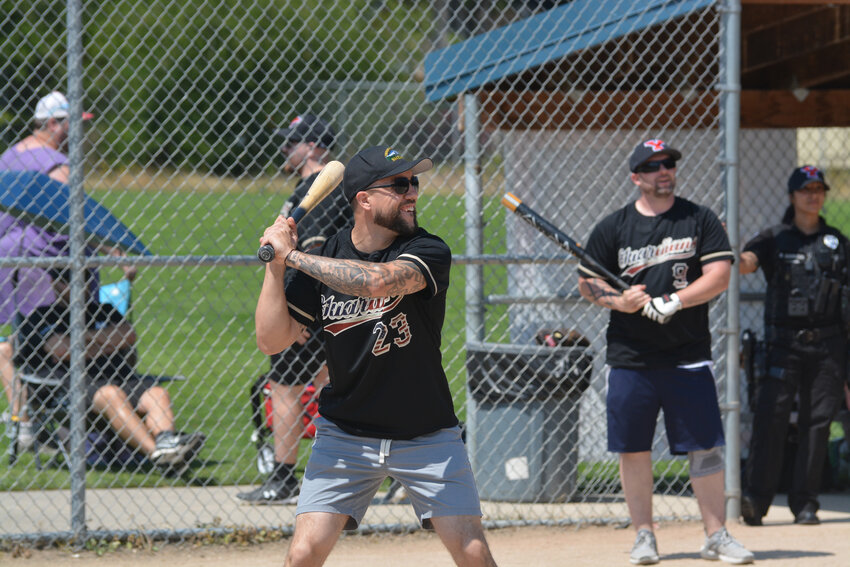 Thurston County Sheriff Derek Sanders loads up to swing at a pitch on June 25 in the charity mushball game.