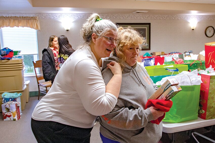 Tammy Vessey, activities director for the assisted living facility and memory care facilty at the Sharon Care Center in Centralia, hugs local volunteer Connie Todd on Tuesday, Dec. 26. For three years now, Todd has collected and delivered Christmas gifts for seniors living in the Sharon Care and other nursing homes in the region.