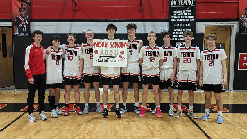 Noah Schow (holding sign) poses for a photo with his teammates after hitting 1,000 career points in Tenino's 64-48 win over King's Way Christian on Dec. 27.