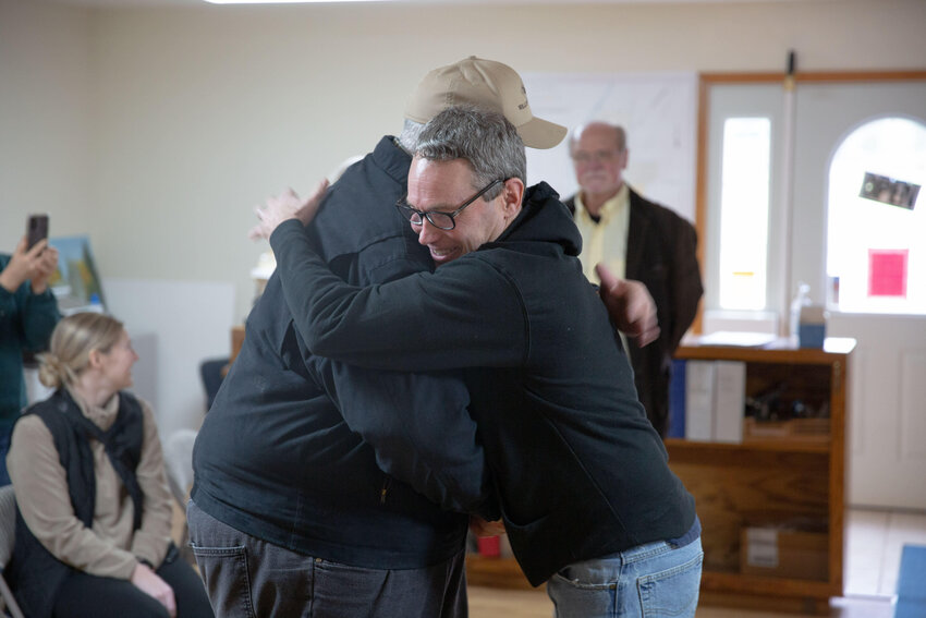 Kevin Aselton, right, hugs Mayor Lonnie Willey, left, upon being greeted during a surprise ceremony at Pe Ell Town Hall Thursday afternoon, Dec. 28.
