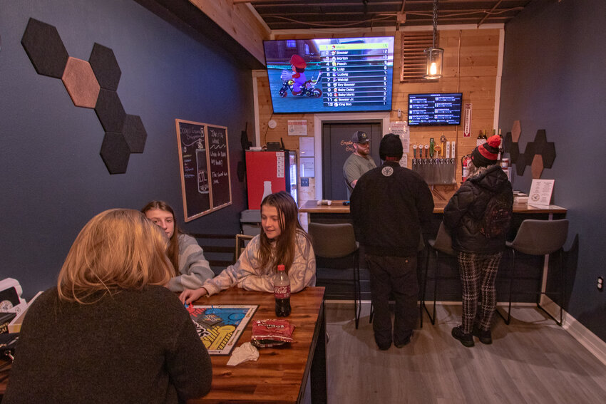 Good Buzz Brewing Co. owner Forrest Chesvick offers samples of his mead to customers at the bar while other customers enjoy a game of Sorry! at a table inside the Good Buzz Brewing Co. taproom in Centralia on Friday, Dec. 29.