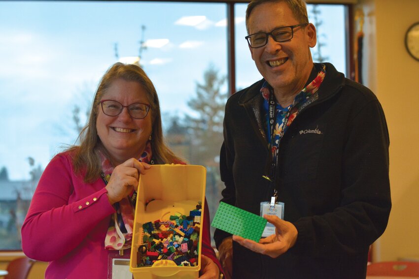 Wendy Stout and Stefan Abaun, with Yelm's Timberland Library, smile for a photo on Dec. 30 while holding one of their LEGO kits.