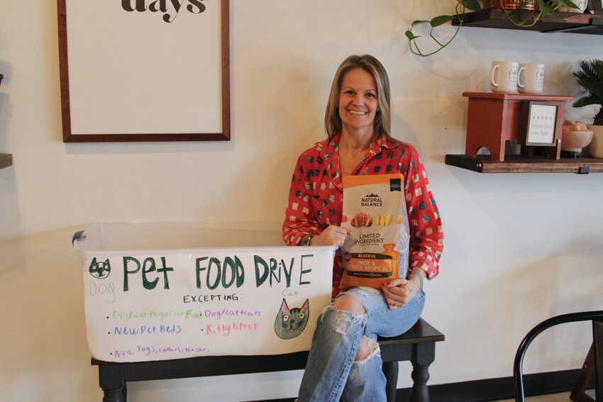 Brandi Worthy smiles with a donated bag of dog food at Worthy Coffee Co. on Jan. 3.