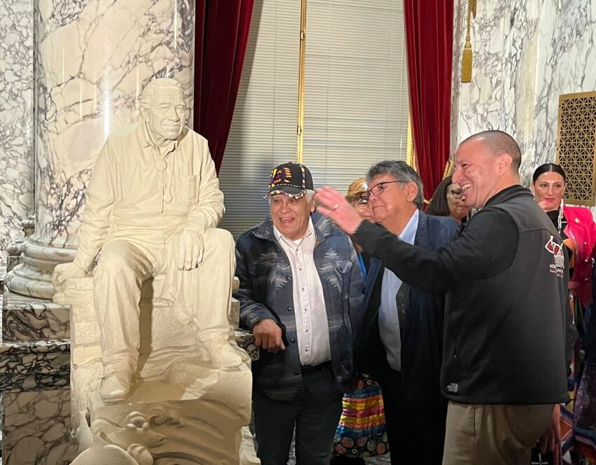 Nisqually Tribal Chairman Willie Frank III, right, discusses the newly designed statue mockup of his father, Billy Frank Jr., with other attendees at Wednesday&rsquo;s unveiling. A full-scale, bronze statue of Billy Frank Jr. will be placed in the U.S. Capitol&rsquo;s National Statuary Hall in Washington, D.C. next year.