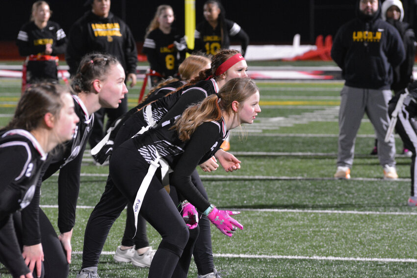Defenders on Yelm High School's girls flag football team set up in their defensive stances prior to Lincoln running an offensive play on Tuesday, Jan. 9.