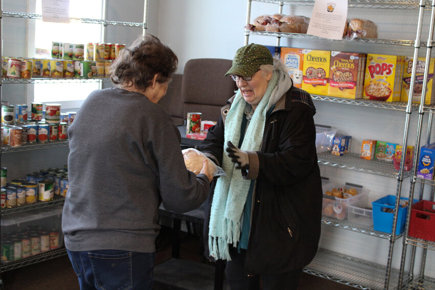 A woman receives a loaf of bread at the Valley Heart Food Pantry on Jan. 10.