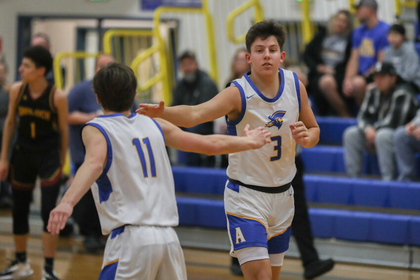 Braeden Salme high-fives Grayson Humphrey (11) after making a basket during the second quarter of Adna's 86-31 win over Winlock on Jan. 18.