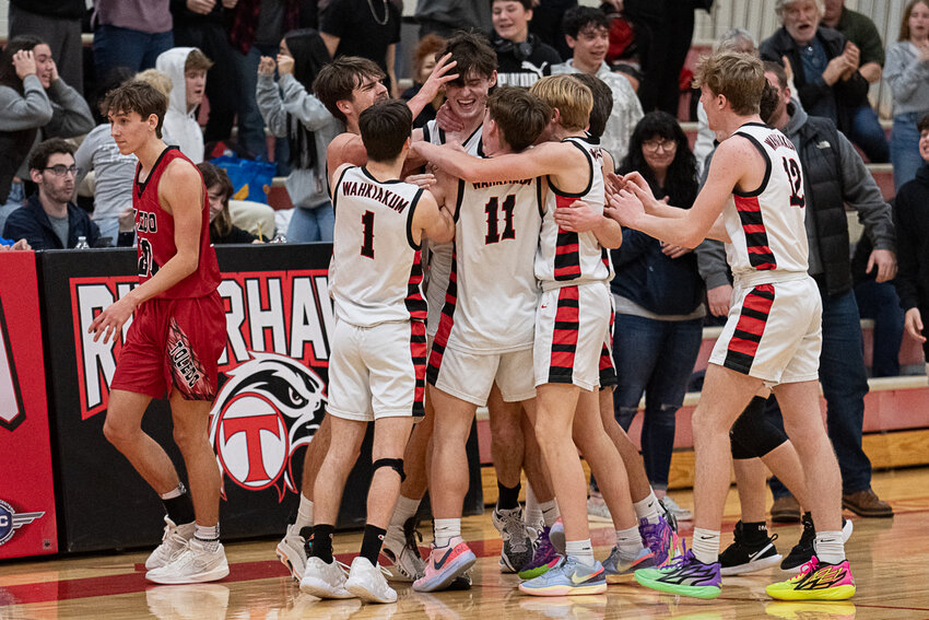 Wahkiakum's Kyler Sauce is swarmed by his teamates after hitting a game-winner in overtime during a 53-52 Wahkiakum victory over Toledo on Jan. 18.