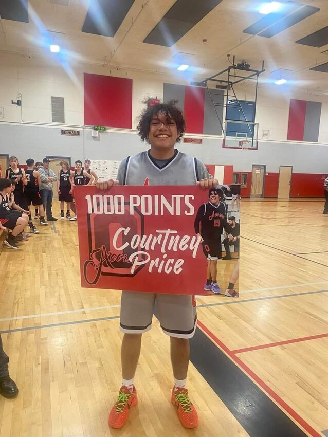 Courtney Price poses with a sign commemorating him hitting the 1,000-point mark during Oakville's win over Wishkah Valley on Jan. 18.