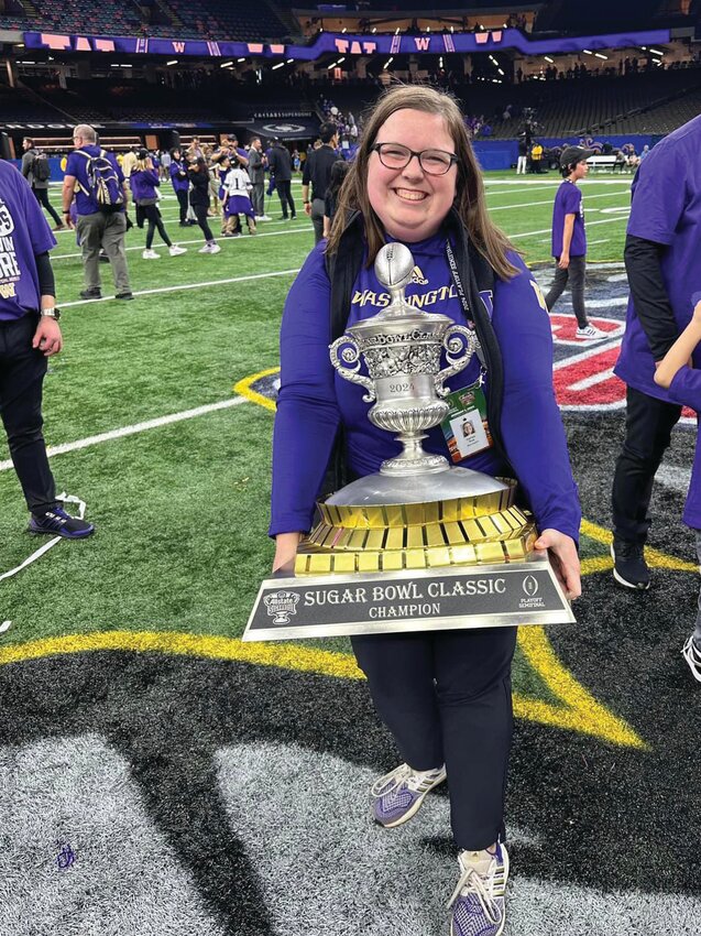 University of Washington assistant director of communications Hailee Roe poses with the Sugar Bowl trophy on Jan. 1 after the Huskies defeated the Texas Longhorns 37-31.