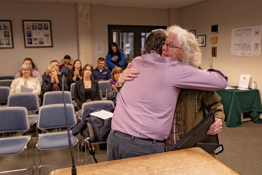 Colleen State hugs Chehalis Mayor Tony Ketchum after a proclamation was made on Monday, Jan. 22, at Chehalis City Hall, honoring her late husband, Jack State, a longtime basketball and tennis coach at W.F. West High School.
