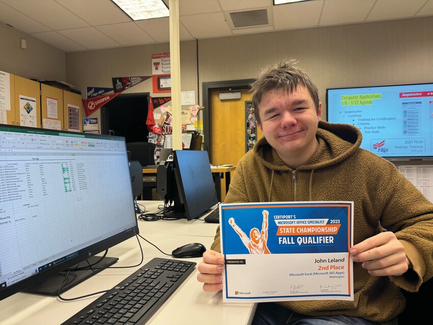 John Leland smiles for a photo with his certificate for second place at the Microsoft Office Specialist Washington State Championship in the Excel category.