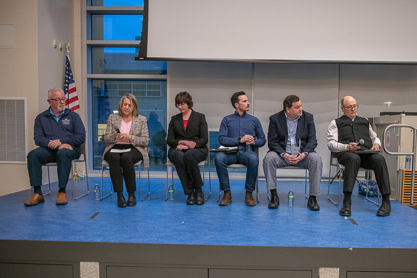 A panel of speakers including, from left, Joe Clark,  Monica Brummer, Lindsey Pollock, Adam Day, Robert Cowin and Bob Russell, takes their seats and prepares to answer questions at the Economics of Clean Energy open panel discussion held at Centralia College on Feb. 5.