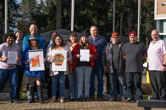 Representatives from the Nisqually Tribe and Parks show off the updated memorandum of understanding and images of the artwork designs for the Park.